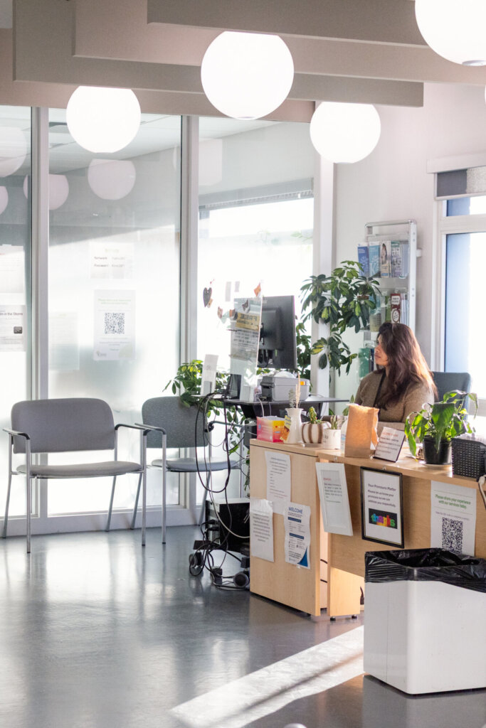 A person sitting at a desk in the klinic waiting room.
